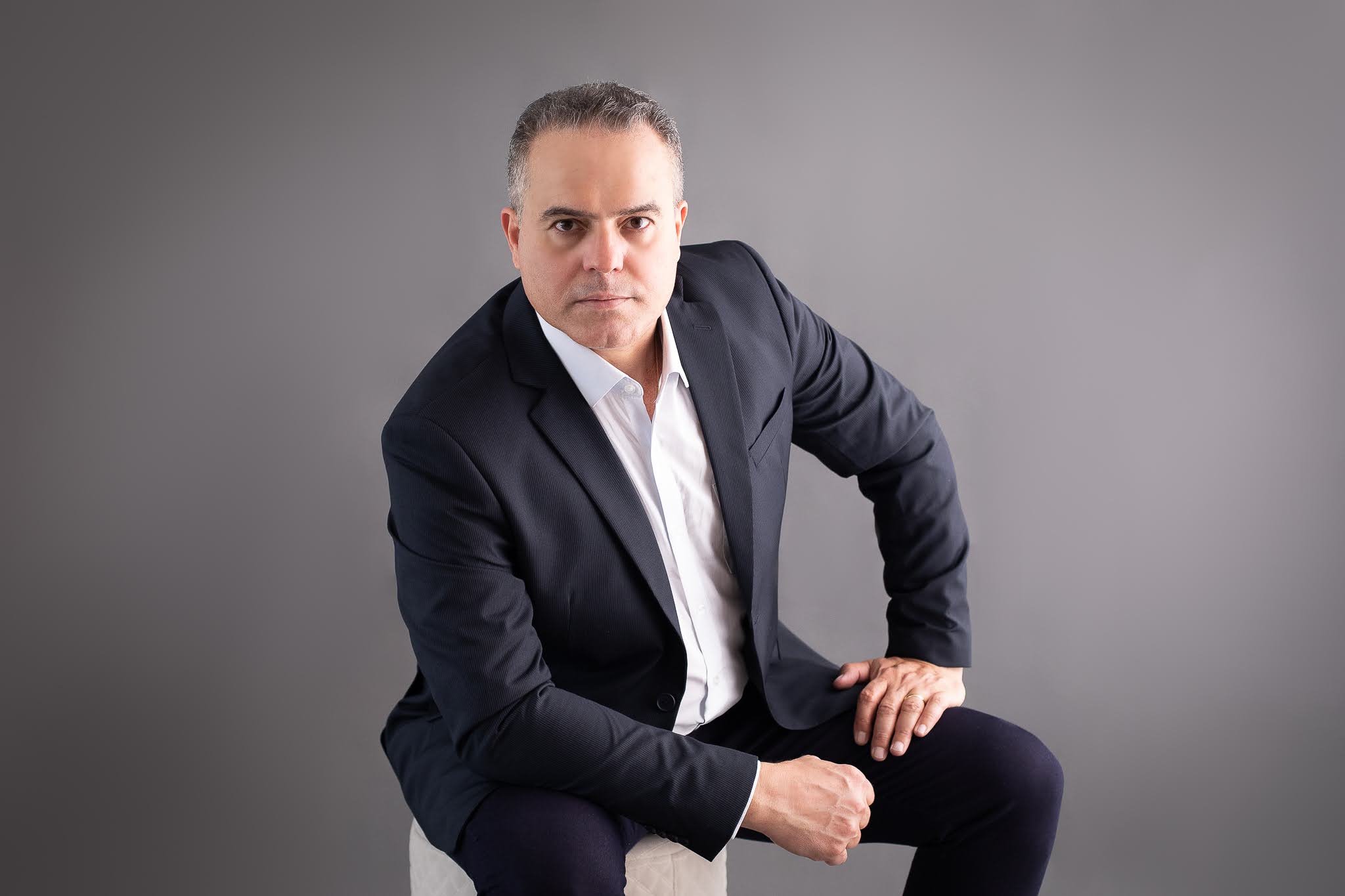 Romerio Fonseca sentado, de terno escuro